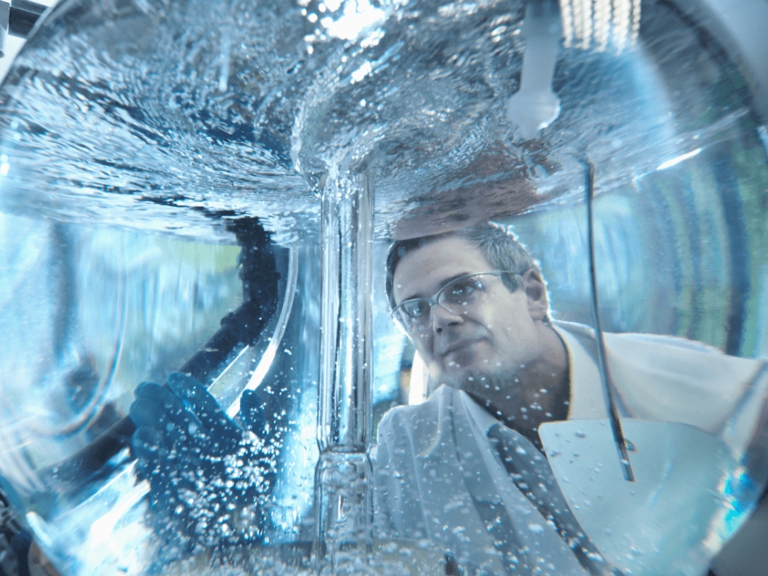 Scientist looking through mixing vessel